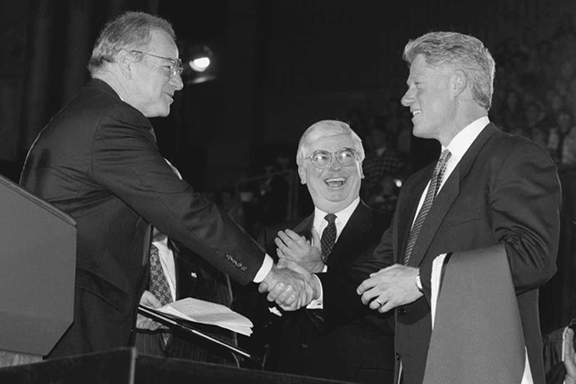President Bill Clinton receives an honorary degree after his address in Gampel Pavilion on the occasion of the opening of the Thomas J. Dodd Research Center in October 1995. Lewis Rome, left, chairman of the Board of Trustees, presents the degree, as U.S. Sen. Christopher Dodd looks on.